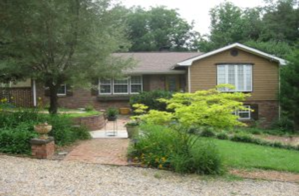 BEFORE gabled roof portico on brick home with trees