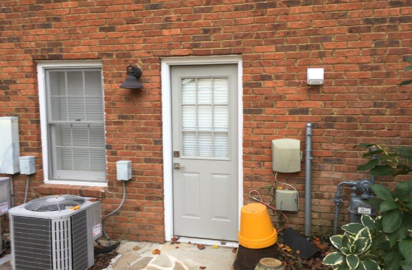 BEFORE side back door portico on brick home with white door