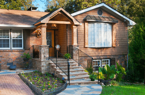 AFTER portico installation on house with wooden shutters and stone steps with metal railing