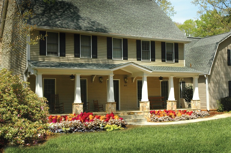 AFTER front porch on craftsman tudor home with white columns on stone