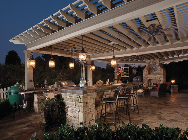 pergola over outdoor kitchen over stone night time