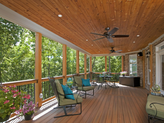 wooden open porch with table and chairs facing woods