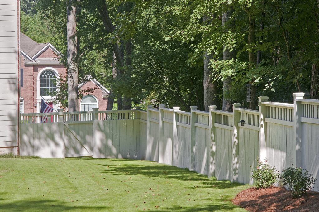 white privacy fence downhill to gate