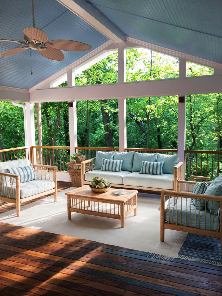 screened porch with light green and beige furniture and white paneling backyard view