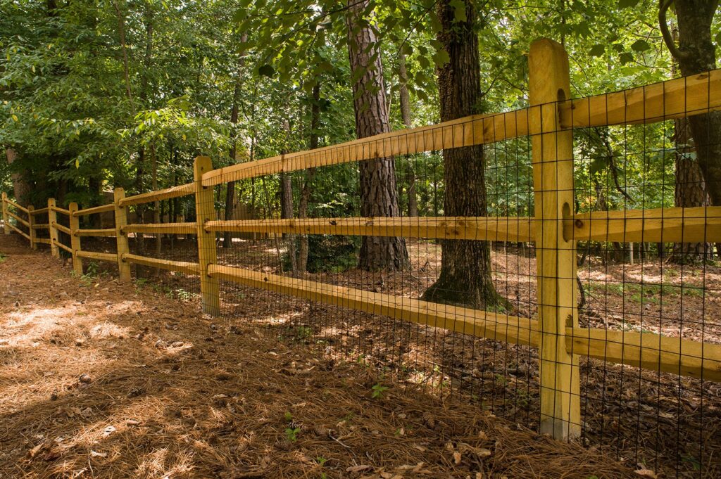 wooden split rail fence with metal barrier