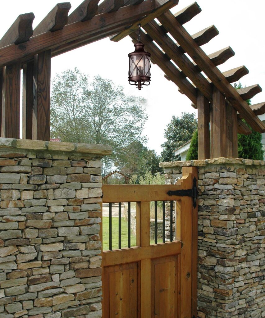 wooden gate with stone wall and wooden arbor